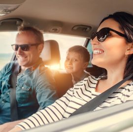 a man and woman sitting in the back seat of a car.