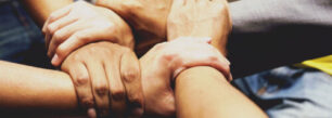 a group of people holding hands in a circle.